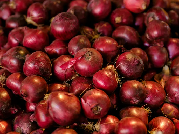a pile of red onions sitting next to each other
